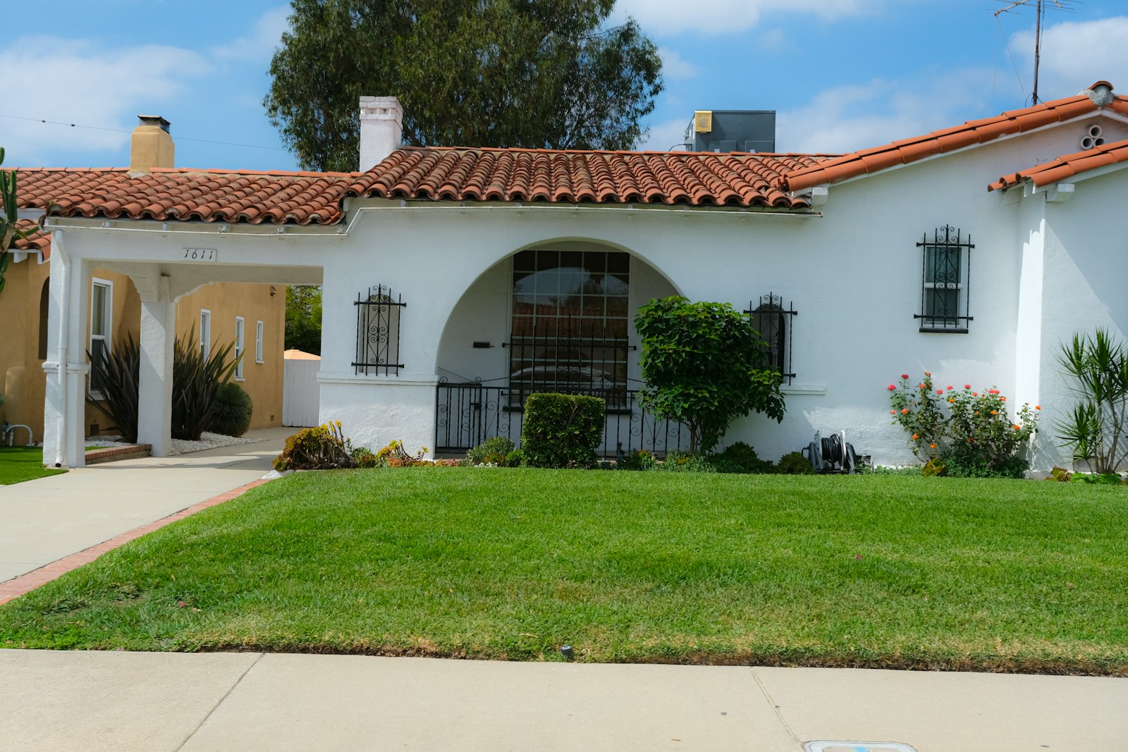 Stucco West Valley home with tile roof, palm, and tidy DG front yard